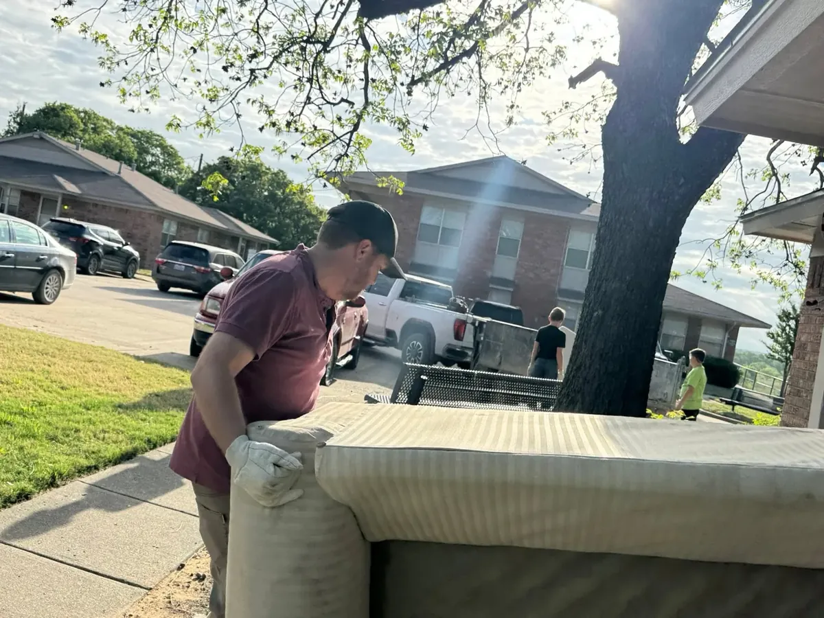Volunteer moving a couch for cleanup