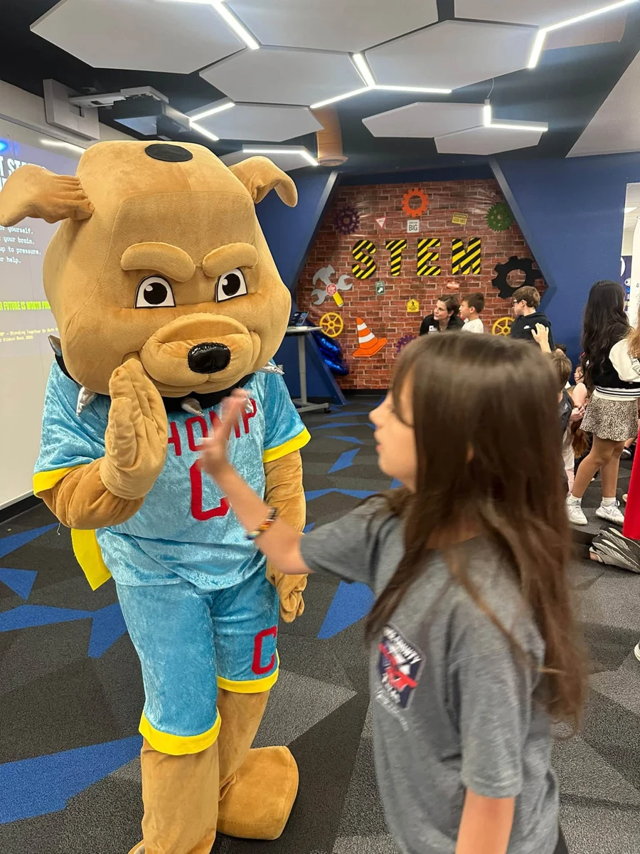 CHOMP mascot greeting a student at Enis Elementary