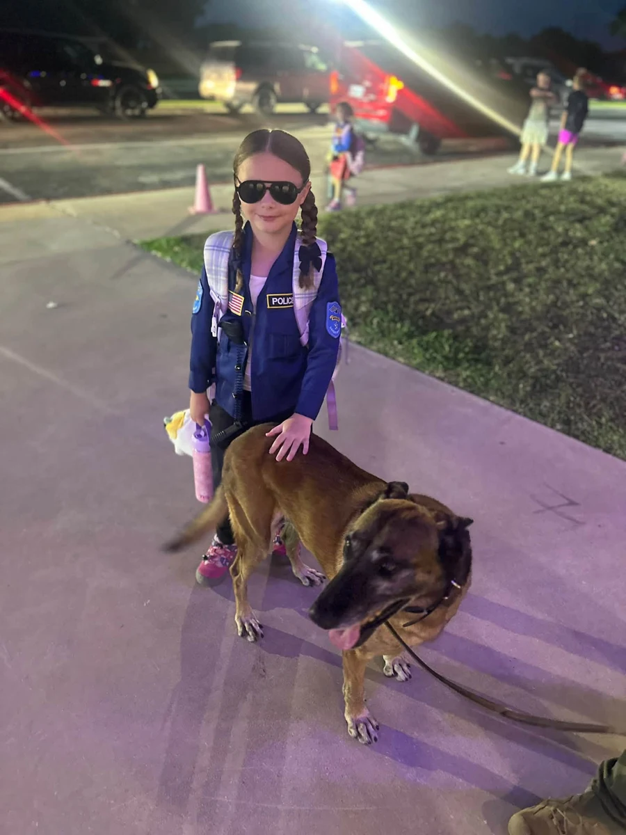 A student posing with a dog outside Enis Elementary