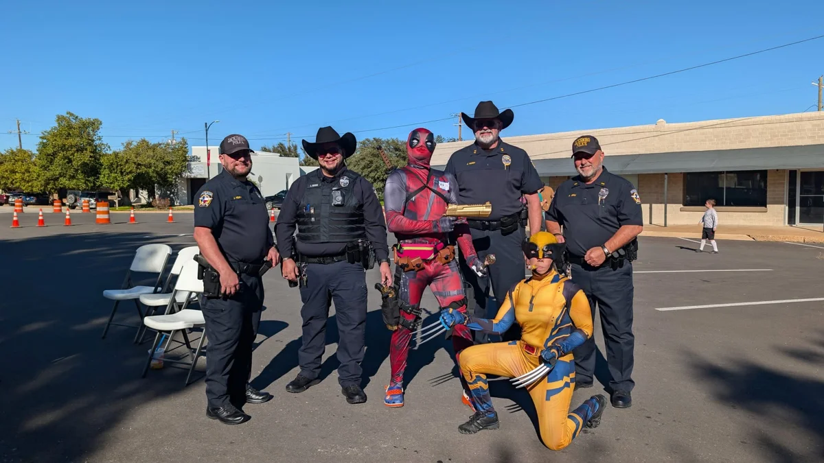 Police officers posing with costumed festival guests at STOMP Fest 2026