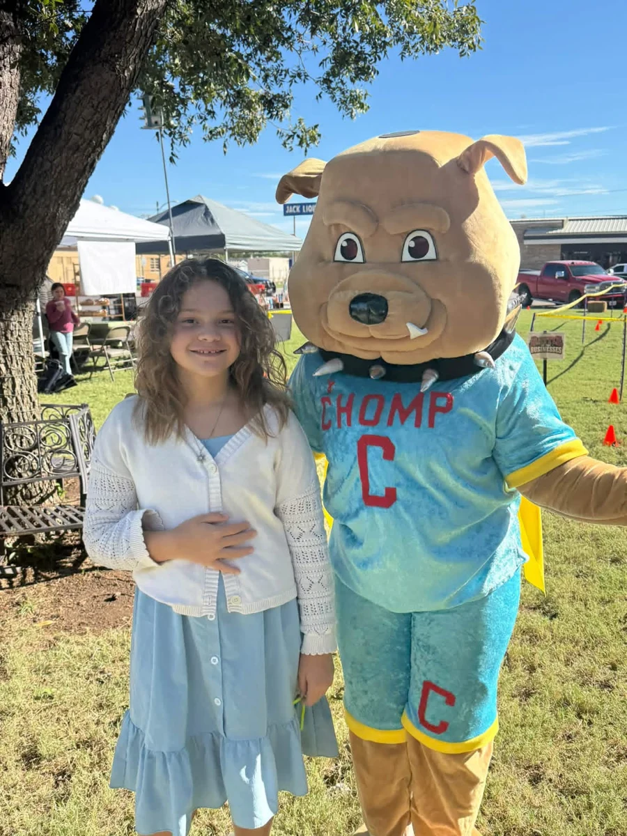 A festival guest posing with the CHOMP mascot at STOMP Fest 2026