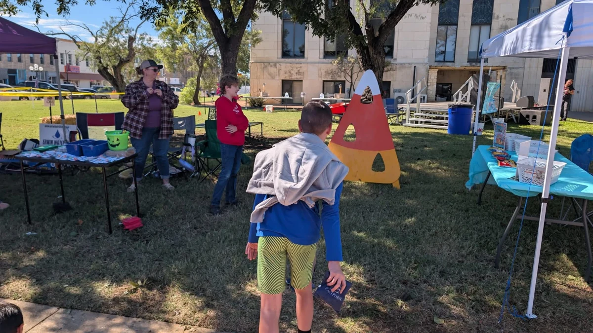 A child playing a festival game near the booths at STOMP Fest 2026