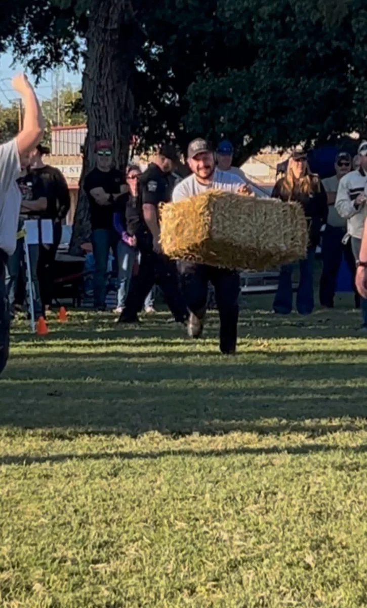 A participant carrying a hay bale during a STOMP Fest 2026 competition